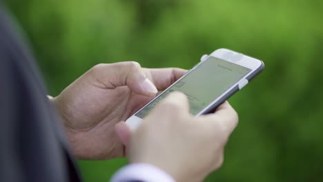 Cropped-shot-of-businessman-texting-by-smartphone-outdoor