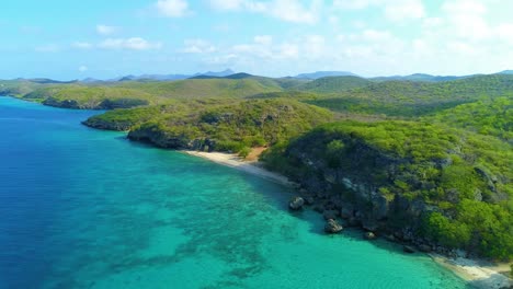 Drone-push-in-above-caribbean-blue-ocean-water-at-San-juan-playa-or-beach,-Curacao