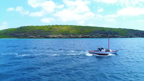 Profile-side-view-tracking-along-fishing-boat-cruising-through-blue-caribbean-ocean-waters