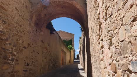 Tilt-down-shot-of-Narrow-stone-alleyway-in-Caceres-old-Town,-Spain