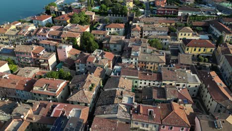 Drone-flyover-looking-down-at-rooftops-of-rustic-Italian-town-in-the-afternoon