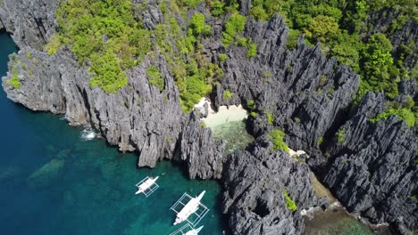 People-swimming-at-the-Secret-beach-in-El-Nido,-philippines-with-island-hopping-tour-boats-against-Karst