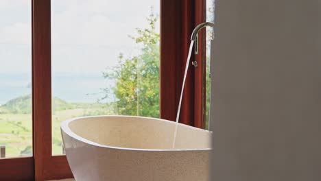 Luxury-stone-freestanding-bathtub-in-hotel-room-with-ocean-view