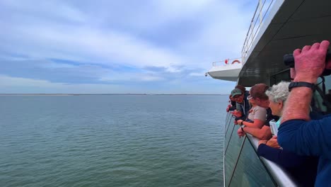 Ferry-passengers-observing-North-and-Wadden-Sea-coastline-with-binoculars