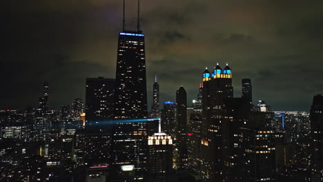 Static-drone-shot-of-the-night-lit-Streeterville-skyline-of-cloudy-Chicago,-USA