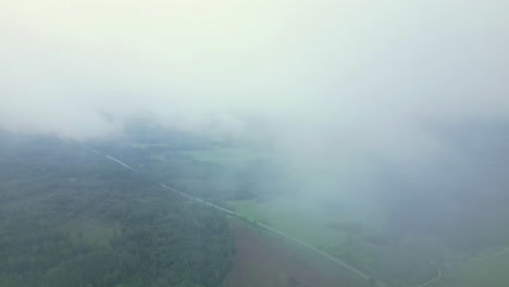 Filmische-Drohnenaufnahmen,-Die-Durch-Wolken-Fliegen,-Mit-Einer-Dramatischen-Landschaft-Darunter,-Aus-Der-Luft
