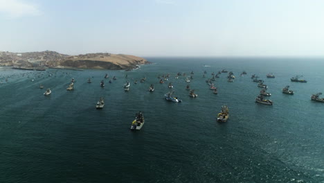 Aerial-view-around-fishing-vessels-moored-on-the-coastline-of-sunny-Huacho,-Peru