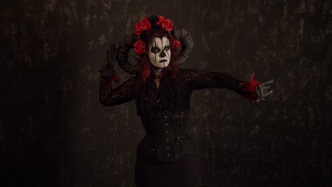 Catrina-Cosplay-girl-moving-slowly-her-arms-and-body-in-a-Dark-background,-Medium-shot