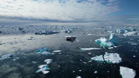 Expedition-vessel-in-cold-freezing-ocean-near-Greenland,-aerial-view