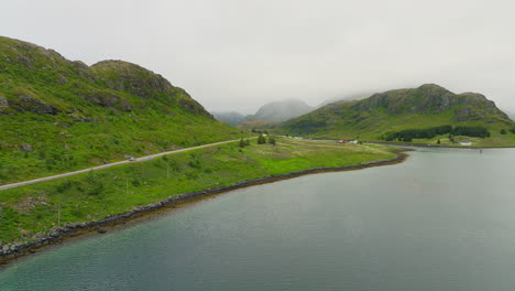 Imagen-Cinematográfica-De-Una-Caravana-Conduciendo-Por-Una-Ruta-Panorámica-A-Través-Del-Paisaje-De-Las-Islas-Lofoten-En-Noruega,-Europa
