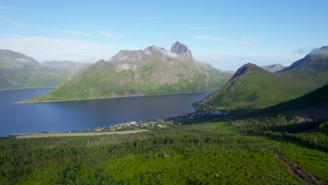 Aerial-reveal-shot-of-the-village-Fjordgard-on-Senja-Norway-showcasing-the-beautiful-vistas-you-will-see-while-on-a-summer-hike-to-Segla-and-Hesten