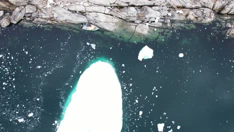 Floating-iceberg-on-deep-ocean-water-surface-near-Greenland-coast,-aerial-view