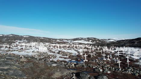 White-crosses-of-Ilulissat-Cemetery,-frozen,-snow-covered-ground