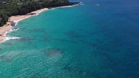 Aerial-wide-tilting-up-shot-of-the-picturesque-North-Shore-coastline-near-Princeville-in-Kaua'i,-Hawai'i
