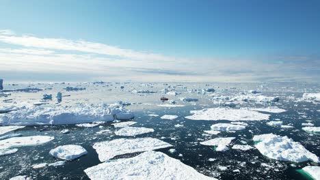 Icebergs-Flotantes-Y-Embarcación-Solitaria-A-Distancia,-Vista-Aérea