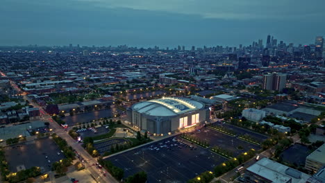 Aerial-view-around-the-illuminated-United-Center-in-Chicago,-blue-hour-in-USA