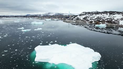 Winter-coastal-landscape-of-Ilulissat,-Greenland-with-calm-seaside-and-icebergs