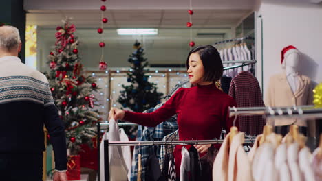 Woman-browsing-though-clothes-in-festive-Christmas-clothing-store,-looking-to-buy-perfect-outfit-for-New-Years-Eve-party.-Customer-in-mall-fashion-boutique-searching-for-ideal-attire