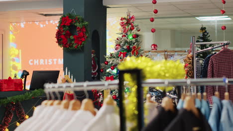 Festive-Christmas-decorated-store-with-wide-variety-of-clothing-on-sale-and-bargains-for-holiday-shopping.-Mall-fashion-boutique-adorn-with-xmas-ornaments-and-formal-attire-racks