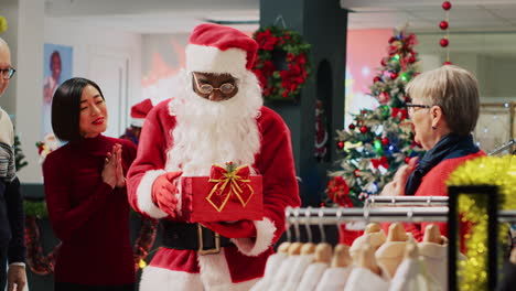 Employee-wearing-Santa-Claus-outfit-in-xmas-adorn-clothing-store,-inviting-customers-to-participate-in-Christmas-raffle-competition-in-order-to-win-promotional-prize-during-winter-holiday-season