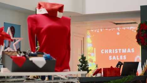 Led-display-advertisement-in-xmas-decorated-clothing-store-announcing-Christmas-sales.-Promotional-animated-billboard-inviting-customers-looking-for-bargains-in-festive-adorn-shop