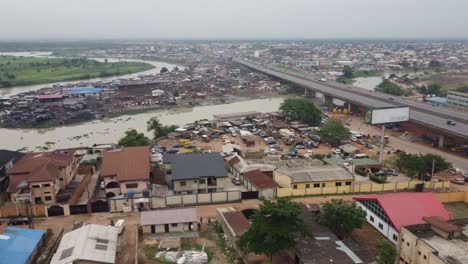 Aerial-view-neighbourhood-in-Lagos-Nigeria-on-a-hazy-day-with-drone-moving-away-from-the-slum-bridge-towards