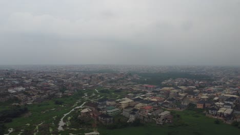 Aerial-view-neighbourhood-in-Lagos-Nigeria-on-a-hazy-day-with-drone-dropping-to-reveal-a-green