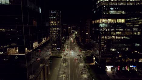 Luftaufnahme-Einer-Nachts-Beleuchteten-Straße-Mit-Autos-Und-Fußgängern,-Person-Auf-Einem-Roller,-Um-Umweltfreundlich-Zu-Sein,-Santiago,-Chile