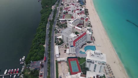 Aerial-View-Over-Cancun-Hotels-and-Resorts-with-a-Tilt-Up-Reveal-of-the-Scenic-Beachfront-with-Turquoise-Waters-Stretching-into-the-Horizon-in-Mexico