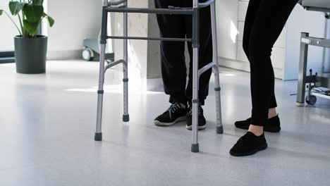 Senior-man-using-a-walker-with-the-assistance-of-a-nurse.