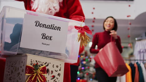 Close-up-shot-of-donation-container-in-fashion-boutique.-Generous-customers-touched-by-festive-spirit-donating-clothes-for-humanitarian-efforts-during-Christmas-holiday-season