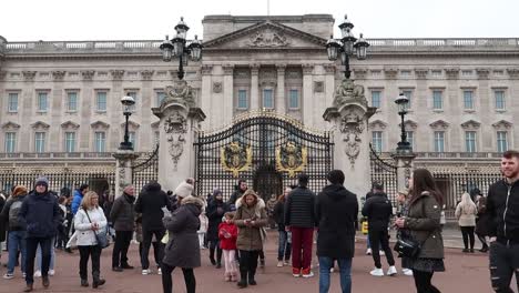 Crowds-of-Tourists-and-visitors-at-Buckingham-Palace-Gates-taking-photos-of-Courtyard,-London