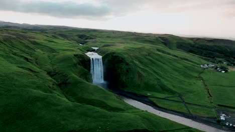 Skogafoss-Waterfall-Surrounded-By-Lush-Landscape-In-Summer-In-Iceland---aerial-drone-shot
