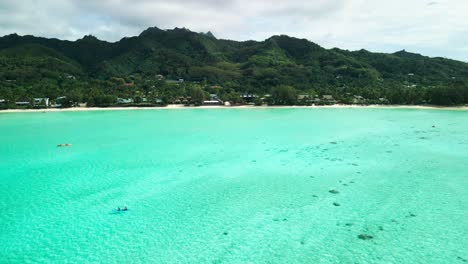 Toma-Aérea-De-Un-Dron-De-Una-Pareja-Haciendo-Kayak-En-La-Laguna-Muri,-Islas-Cook-Rarotonga