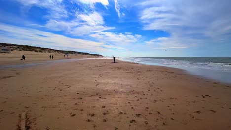 POV-walk-over-Dutch-beach-at-Texel-with-sand,-people,-sea-and-waves