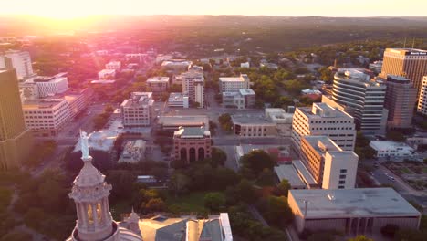 Austin-Texas-State-Capital-Building,-Aerial-Drone-Shot-Circling-the-Goddess-of-Liberty-Statue-on-Top-with-Views-of-The-University-of-Texas-at-Austin-and-Downtown-City-Buildings-Skyline-at-Sunset-in-4K