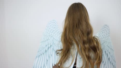 Back-side-of-a-woman-in-a-dress-wearing-angel-wings