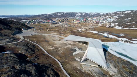 Icefjord-Visitor-Centre,-tourist-attraction-and-Ilulissat-village-on-Greenlandic-coast---aerial