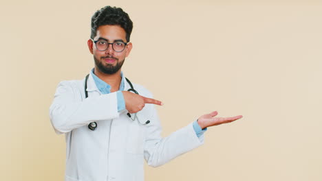 Doctor-man-showing-thumbs-up-and-pointing-on-blank-space-place-for-advertisement-promotion-logo