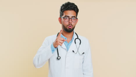 Indian-doctor-man-shakes-finger-and-saying-no,-be-careful,-avoid-danger-mistake,-disapproval-sign