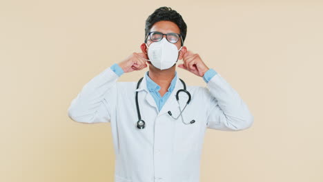 Happy-Indian-doctor-man-removing,-taking-off-medical-protective-mask,-ending-of-flu-pandemic