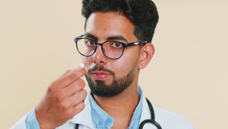 Indischer-Arzt,-Mann-Steckt-Weiße-Kapsel,-Tablette,-Pille-In-Den-Mund,-Empfiehlt-Medikamente,-Vitamin-Impfung