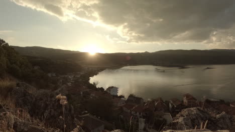 Zeitraffer-Eines-Sonnenuntergangs-In-Lin-Albanien-Am-Abend-Mit-Blick-Auf-Das-Wasser-Und-Die-Berge-Im-Hintergrund-An-Einem-Klaren-Tag-Mit-Orangefarbenem-Himmel