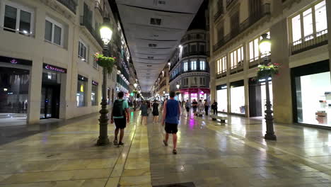 Gente-Caminando-En-La-Calle-De-Tiendas-En-El-Centro-De-Málaga-Por-La-Noche