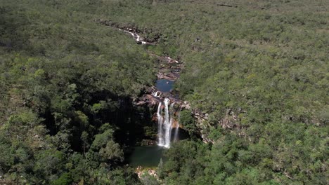 aerial-view-of-the-Catedral-waterfall-and-Macaco-river-in-Complexo-do-Macaco-in-Chapada-dos-Veadeiros-Goiás-Brazil,-waterfall,-rocks-and-vegetation-of-the-cerrado