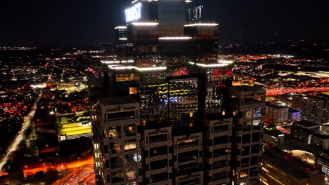 Cinematic-drone-shot-around-mirrored-Truist-Plaza-and-illuminating-cityscape-of-Atlanta-City-at-midnight