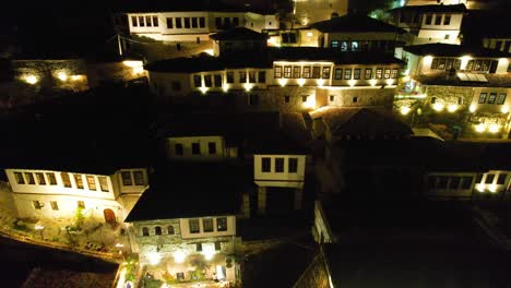 Berat-Mangalem-Neighborhood-Houses-at-Night-with-Illuminated-Windows-and-Verandas,-Welcoming-Tourists-to-Guest-Houses-and-Hotels