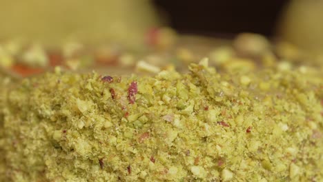 Pistachio-donut-being-decorated-close-up-nuts