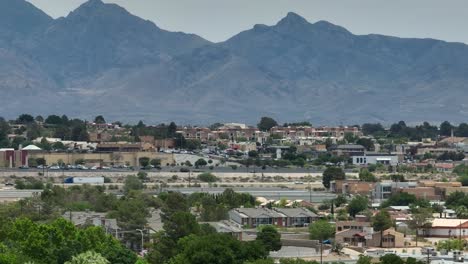 Houses-and-homes-in-neighborhood-in-Southwest-USA-shadowed-by-tall-mountain-range-in-desert