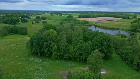 Aerial-drone-view-moving-slowly-through-a-countryside-landscape-with-a-lake